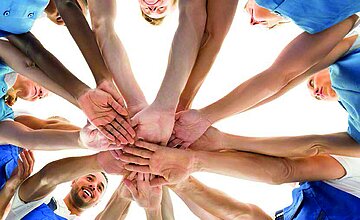 Bild zeigt viele Hände bilden Kreis